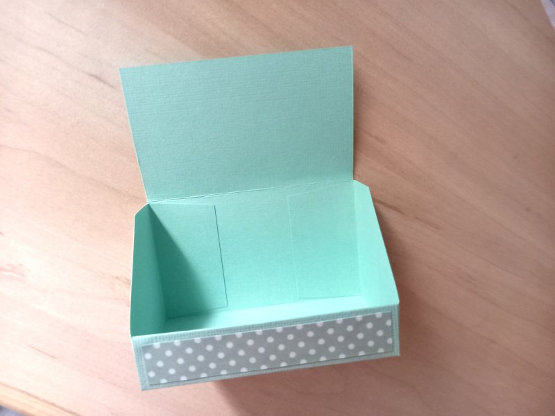 A business card display box made from mint green cardstock and decorated with white spotty card holding 100 business cards.