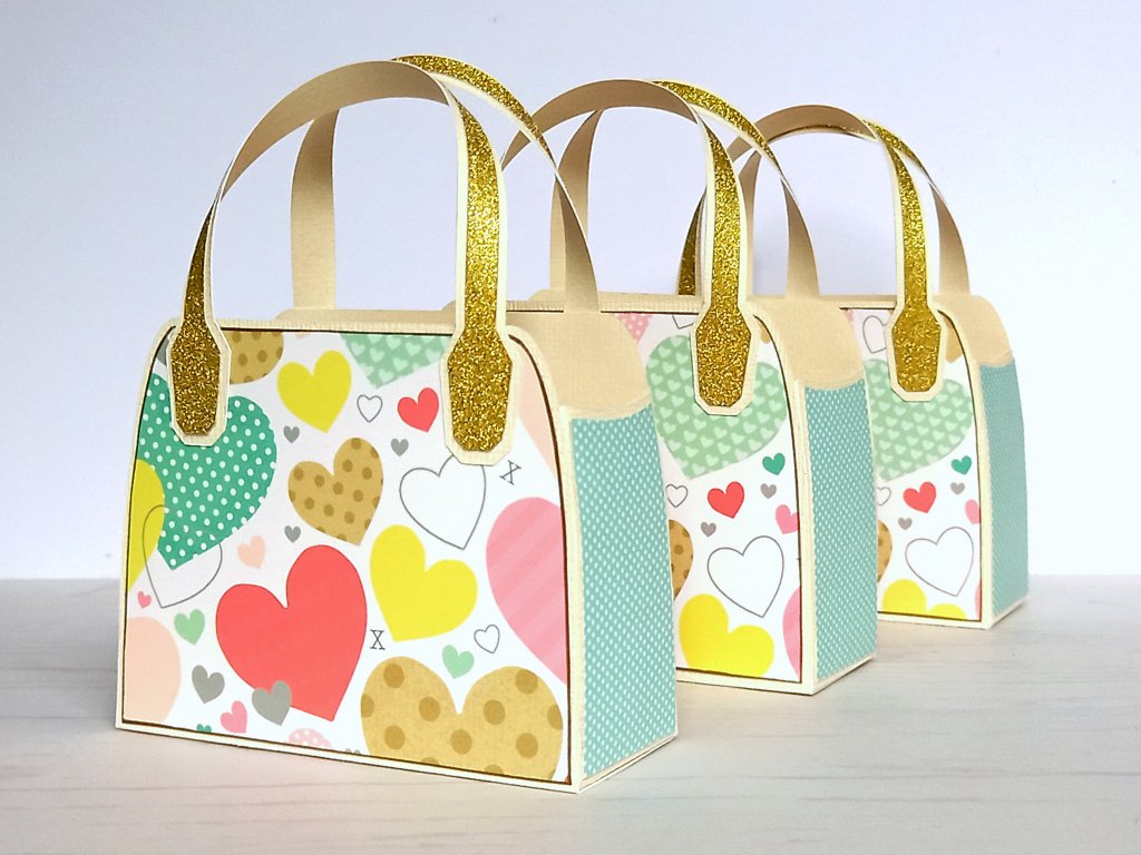 Three white upcycled favour bags with pastel heart design