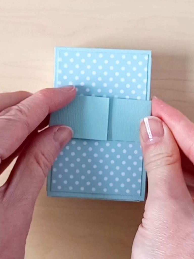 The front of a business card holder made from mint green cardstock and decorated with white spotty card used to hold 70 business cards