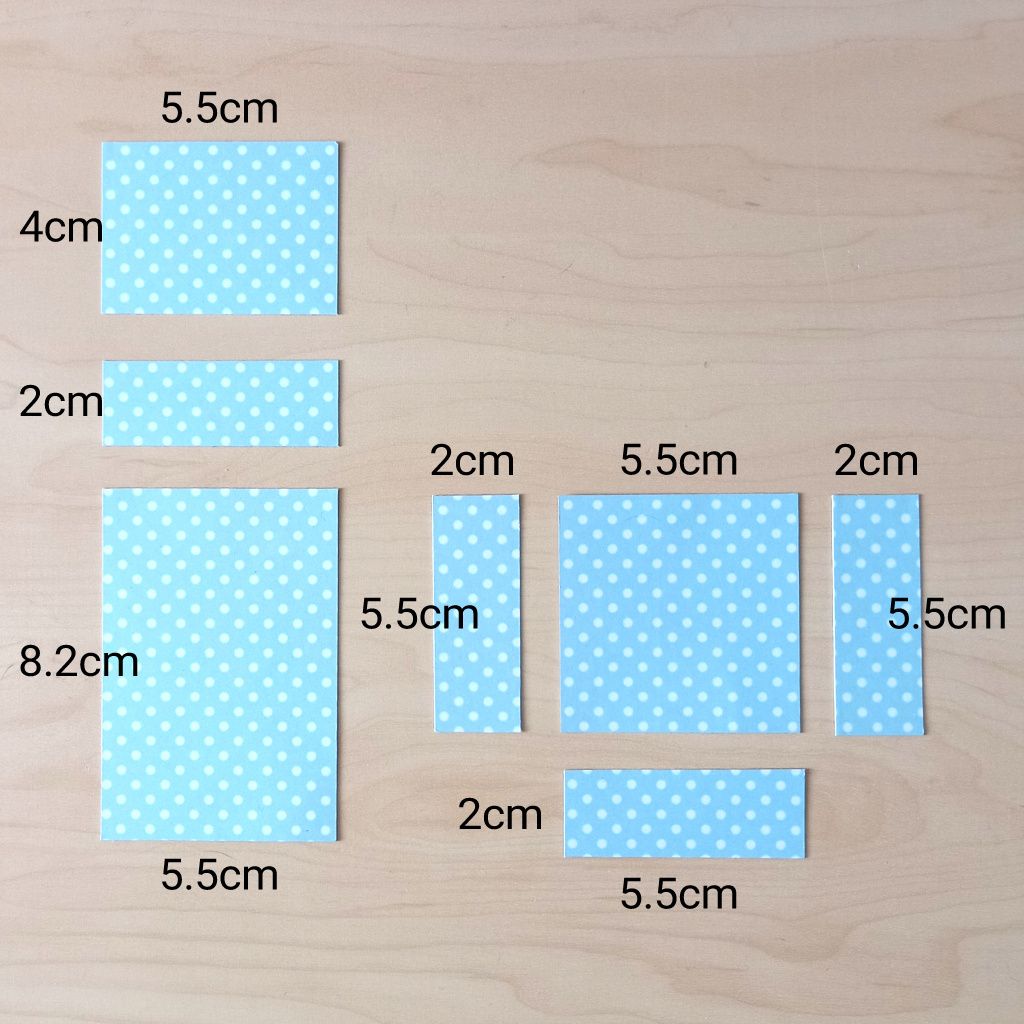 Seven pieces of mint green and white spotty card cut out to size to decorate a business card holder