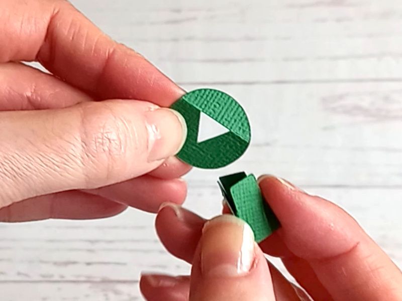 A papercraft gift box in the shape of a cauldron, showing how to assemble the feet.