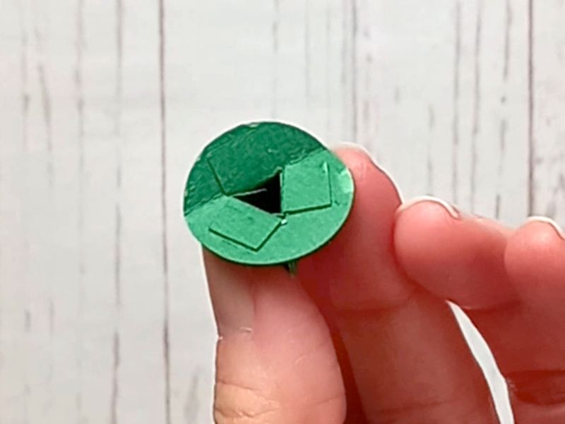 A papercraft gift box in the shape of a cauldron, showing how to assemble the feet.