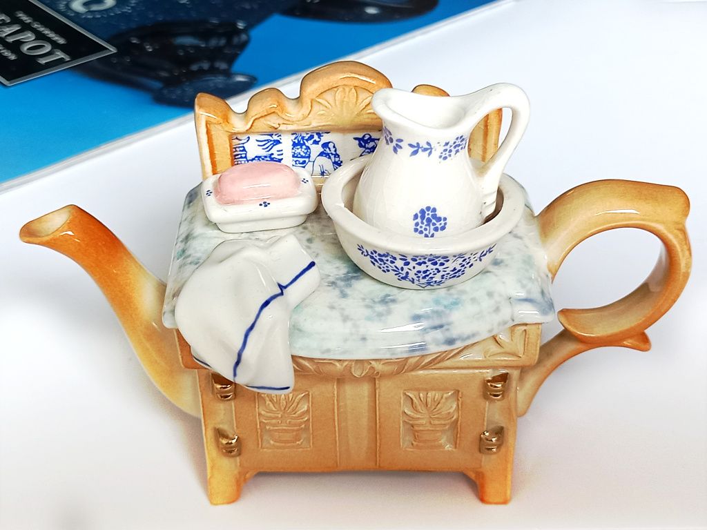A one cup novelty teapot designed to look like a Victorian wash stand with a small jug and bowl as the teapot lid