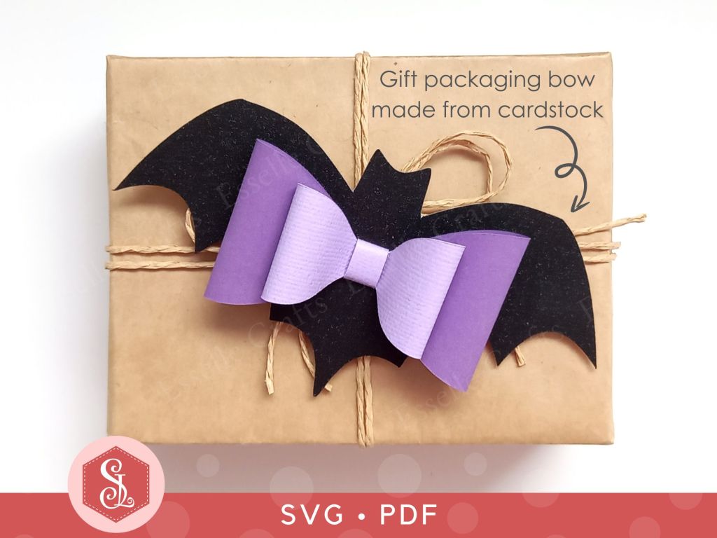 A black and purple bat bow made from textured cardstock that can be used on Halloween gift packaging or home decor