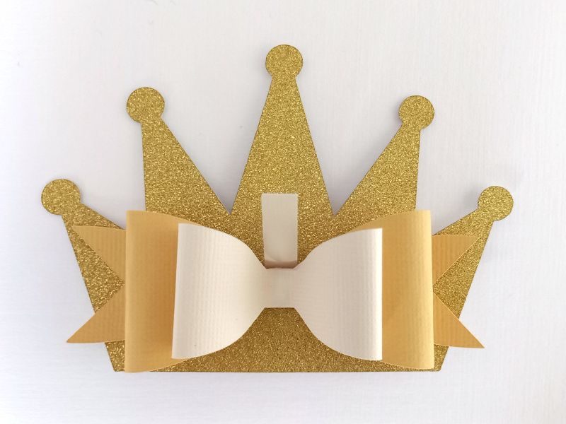 A princess crown bow made from gold glitter cardstock that can be used on gift packaging or home decor