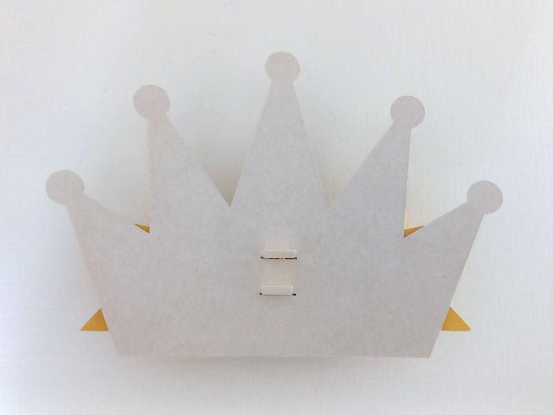 A princess crown bow made from gold glitter cardstock that can be used on gift packaging or home decor
