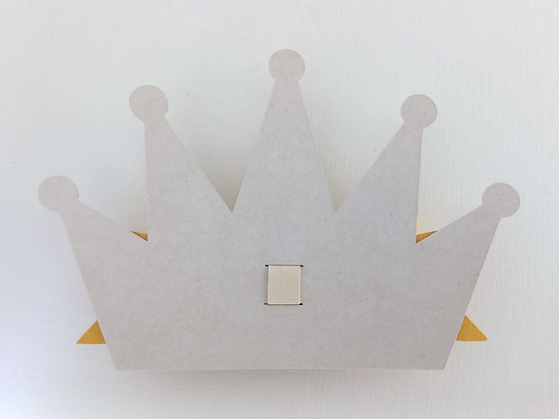 A princess crown bow made from gold glitter cardstock that can be used on gift packaging or home decor