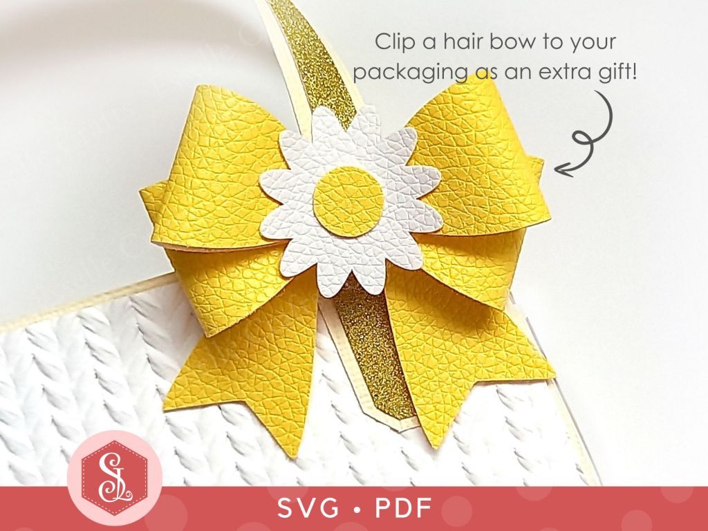 A hair bow made from yellow faux leather with a white and yellow faux leather daisy in the centre for adding to a hair clip or headband