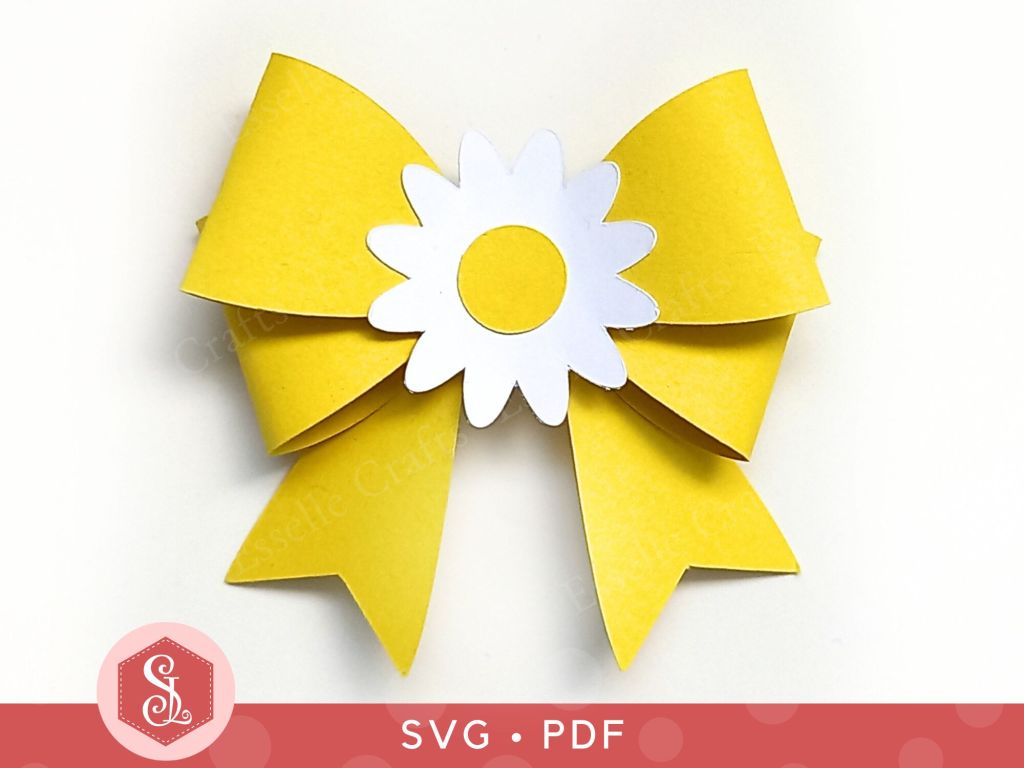 A papercraft gift bow made from yellow cardstock with a white and yellow paper daisy in the centre for adding to gift packaging