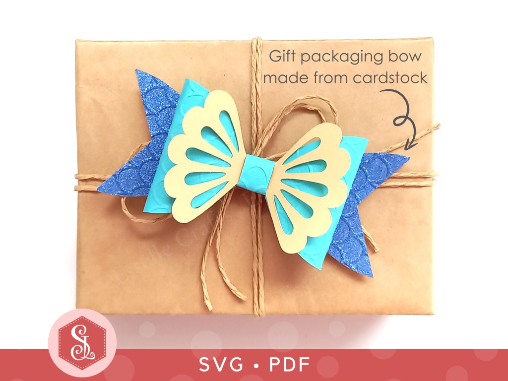 A mermaid gift bow made from blue glitter cardstock and teal and cream cardstock that can be used on gift packaging or home decor