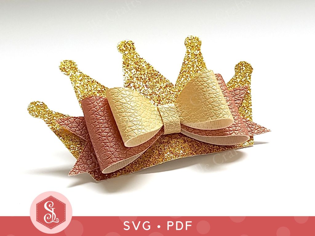 A princess crown bow made from faux leather and thin gold glitter fabric that can be used as a hair bow or a brooch
