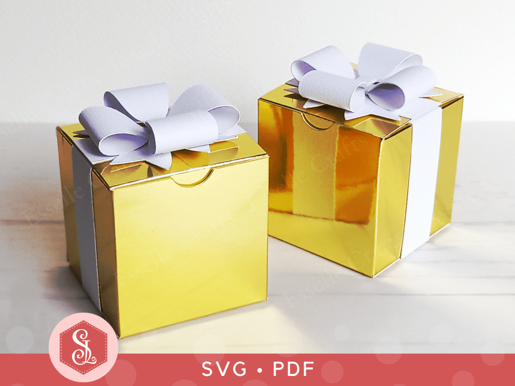 Double Bow Boxes by Esselle Crafts Two cube favour boxes made from shiny gold card, finished with a white paper ribbon and a white double bow on top.