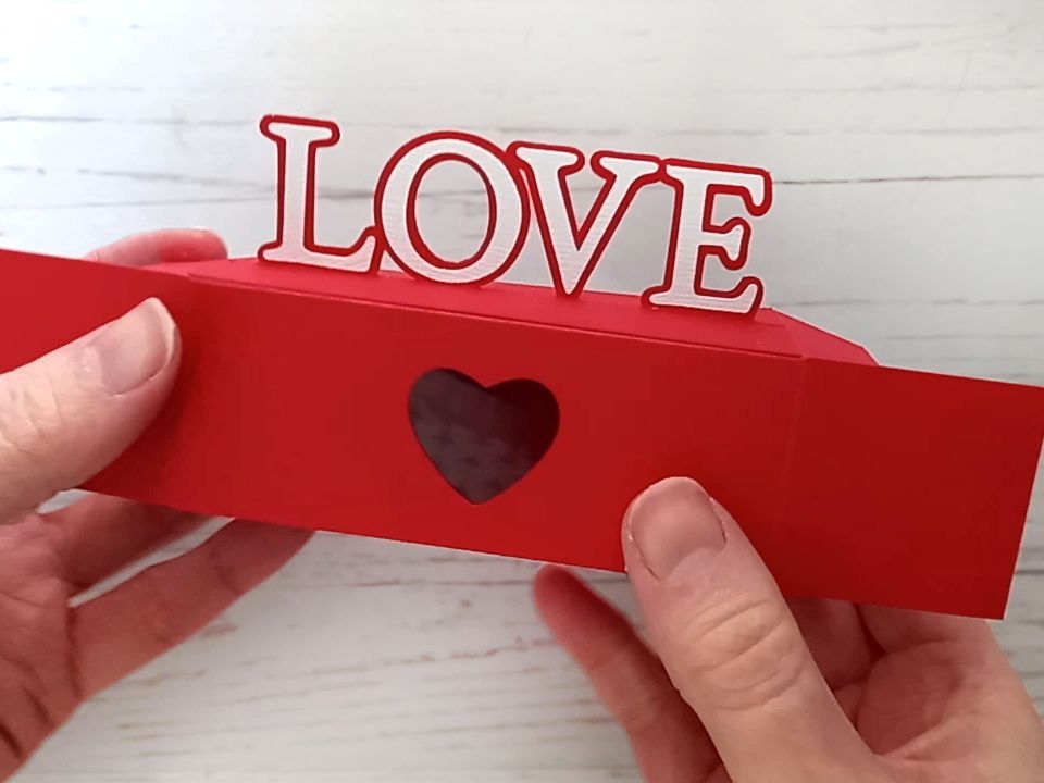 A red papercraft treat box for Valentine's day with the word LOVE on the top