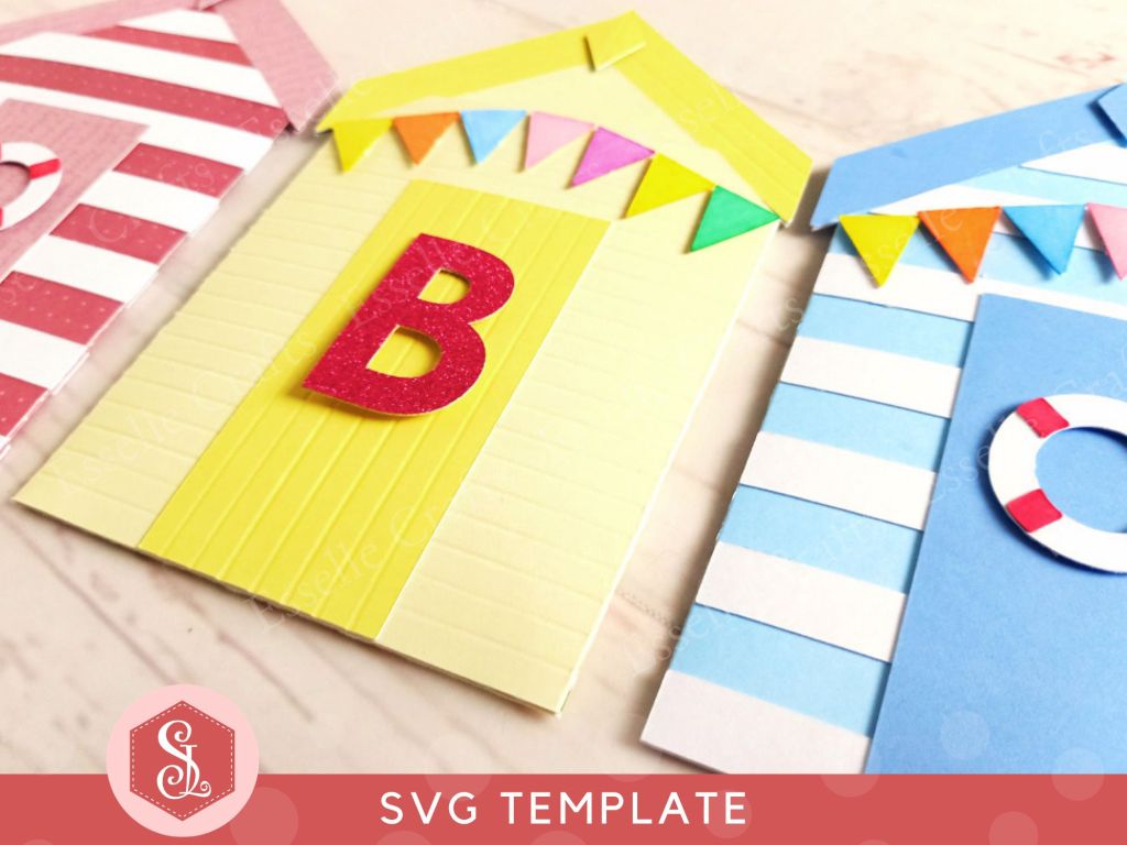 A papercraft gift card holder in the style of a beach hut, decorated with a red and white lifebuoy, colourful paper bunting and personalised with a letter B on the door.