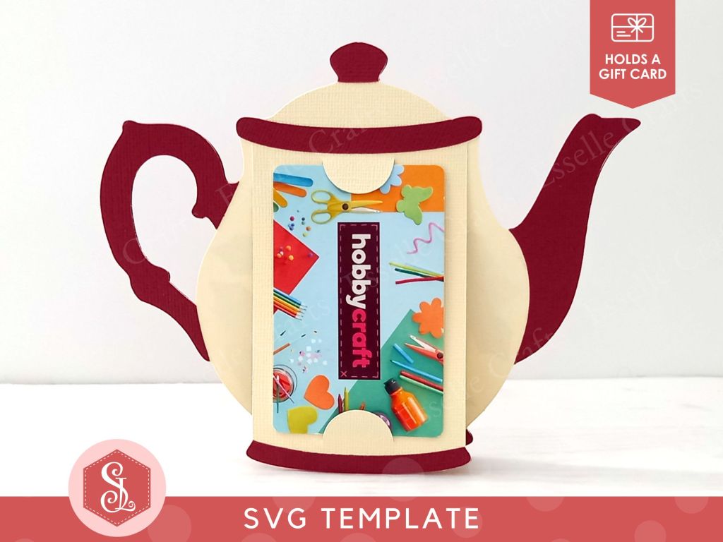 A papercraft gift card holder in the style of a vintage cream teapot with a dark red handle and spout. It is holding a Hobbycraft gift card in the back.