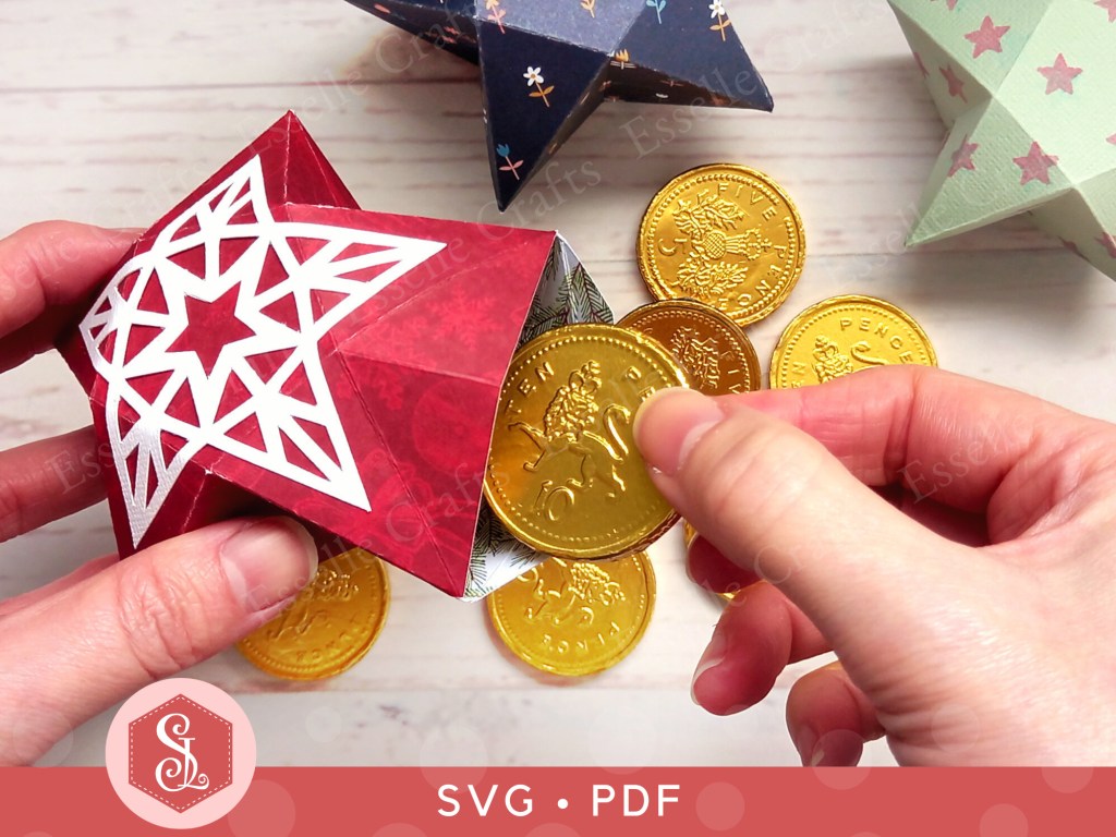 A red papercraft favour box in the shape of a star with a white decorative panel on top used for gifting sweets or small treats.