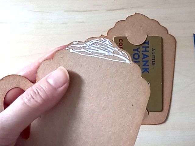 A papercraft gift card holder in the shape of a cosy Christmas mug. It is holding a Costa thank you gift card in the back.