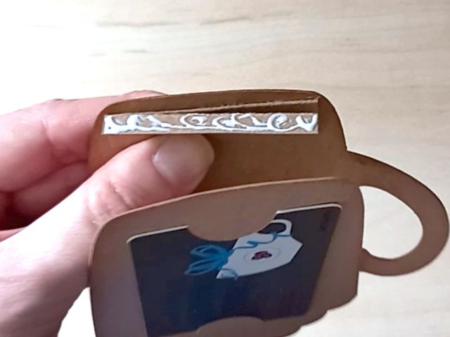 A papercraft gift card holder in the shape of a cosy Christmas mug. It is holding a Costa thank you gift card in the back.